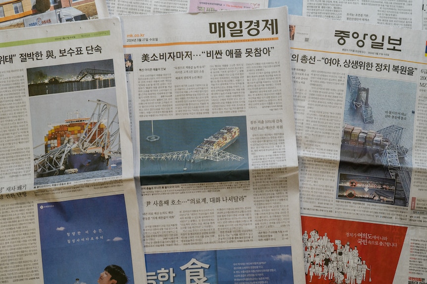 照片插图显示了韩国报纸的头版，上面有美国巴尔的摩倒塌桥梁的照片。