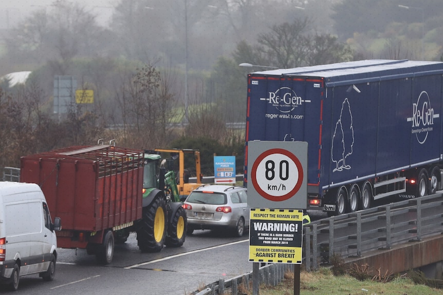 A line of traffic which consists of cars and trucks.