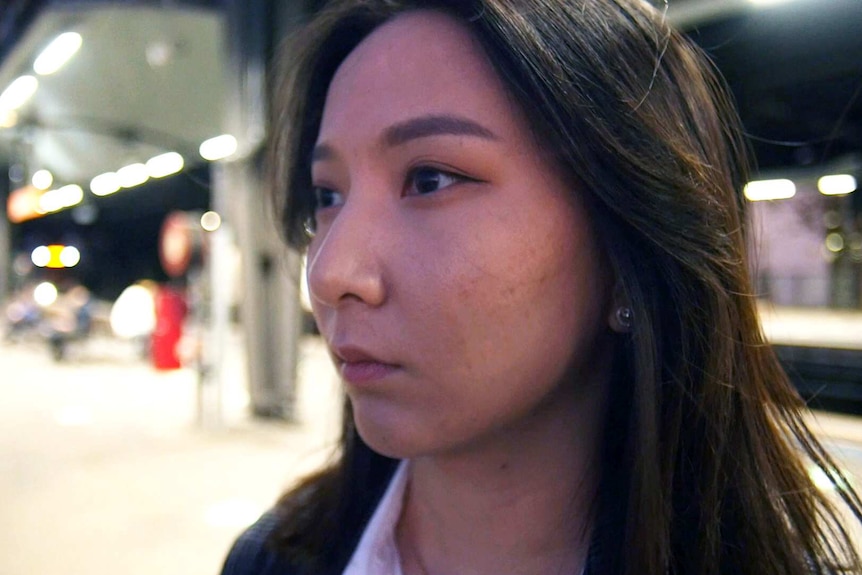 International student, Jin, standing on a railway station platform at night