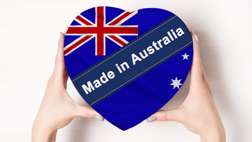 Inscription Made in Australia the flag of Australia. Female hands holding a heart shaped box. White background