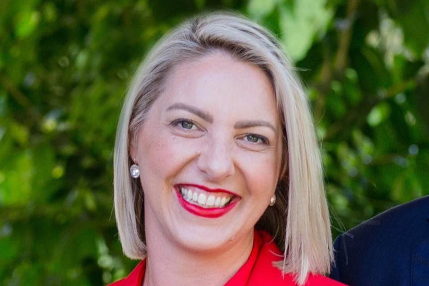 A picture of a smiling woman wearing red.