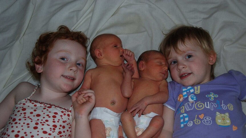 Ellen Daly lies on the bed with her sister Grace and their newborn twin siblings William and Emmaline