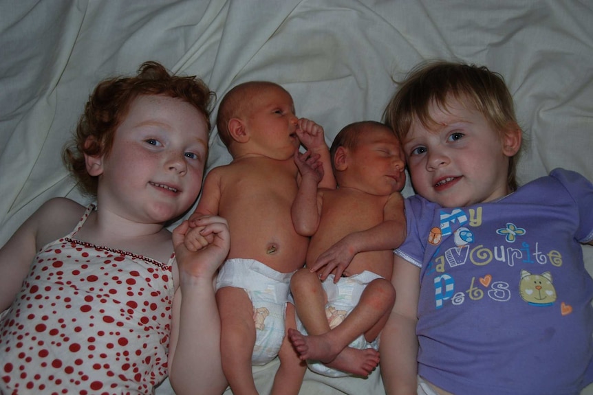 Ellen Daly lies on the bed with her sister Grace and their newborn twin siblings William and Emmaline