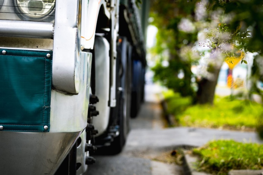 A close up picture of a large truck parked on the side of a road