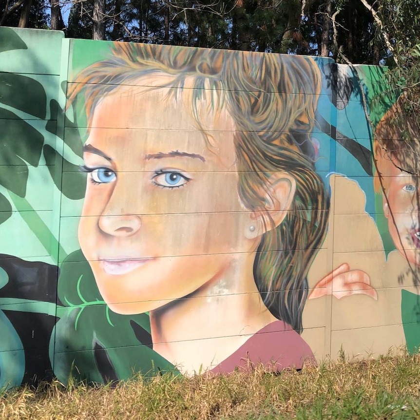Street art of young girl on a soundwall.