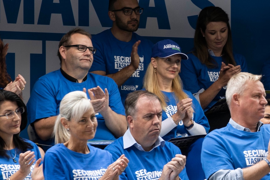 A group of people standing together, wearing matching blue Liberal Party t-shirts