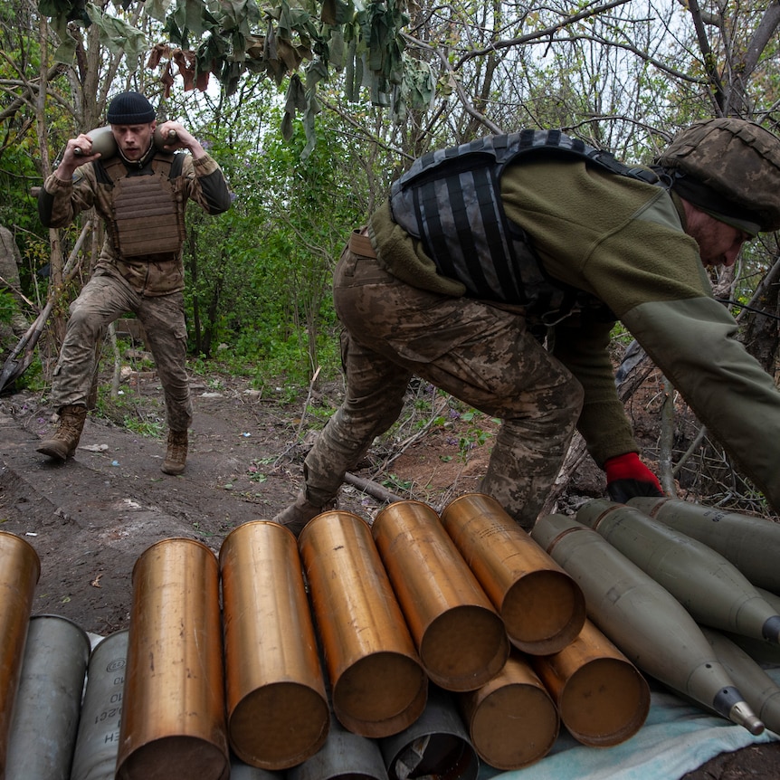 Ukrainian soldiers prepare self-propelled howitzer shells.