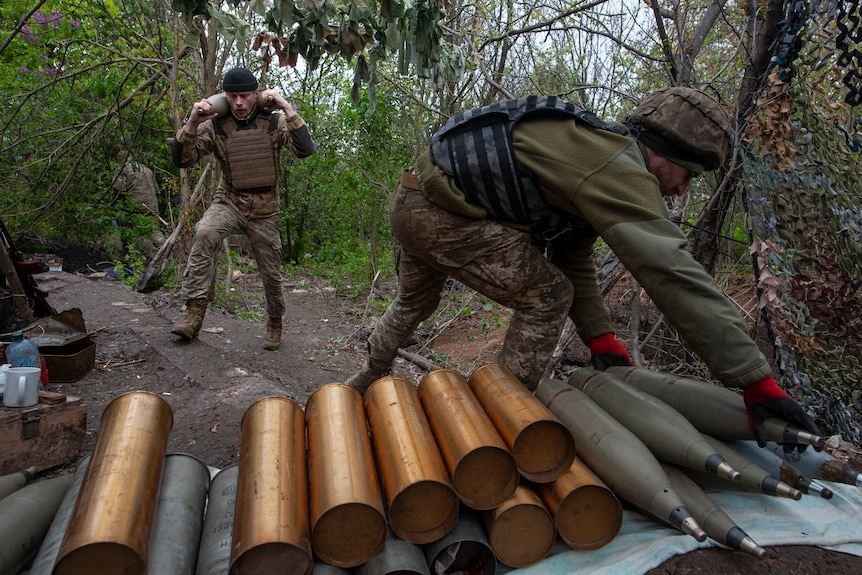 Ukrainian soldiers prepare self-propelled howitzer shells.