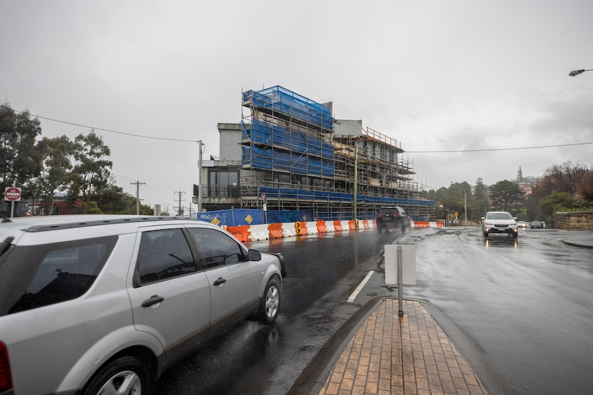 Cars pass a multi-level construction site in Hobart.