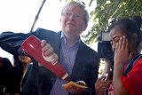 Kevin Rudd serves sausages to students