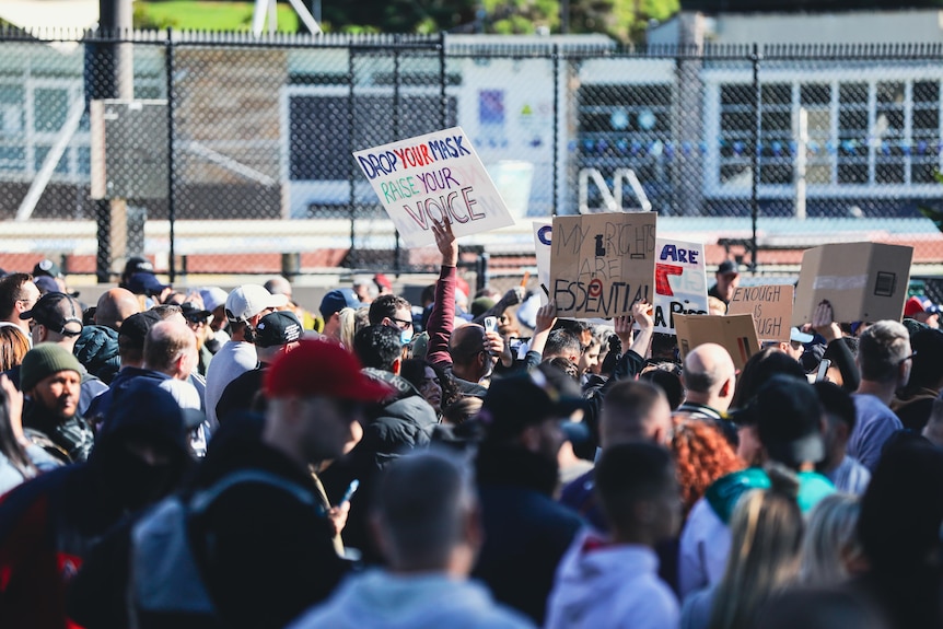 a large crowd of people holding signs 