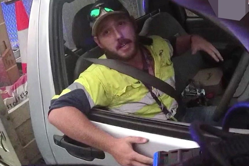 A man leaning out the driver's window of a ute