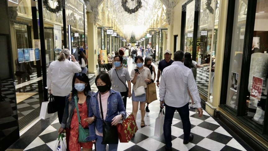 People wearing masks and carrying shopping in an arcade in Melbourne's CBD.