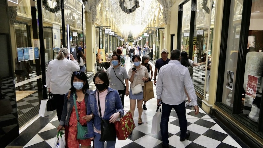 People wearing masks and carrying shopping in an arcade in Melbourne's CBD.