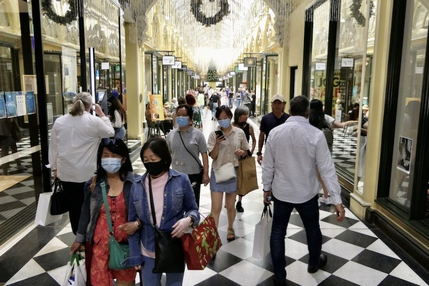 People wearing masks and carrying shopping in an arcade in Melbourne's CBD.