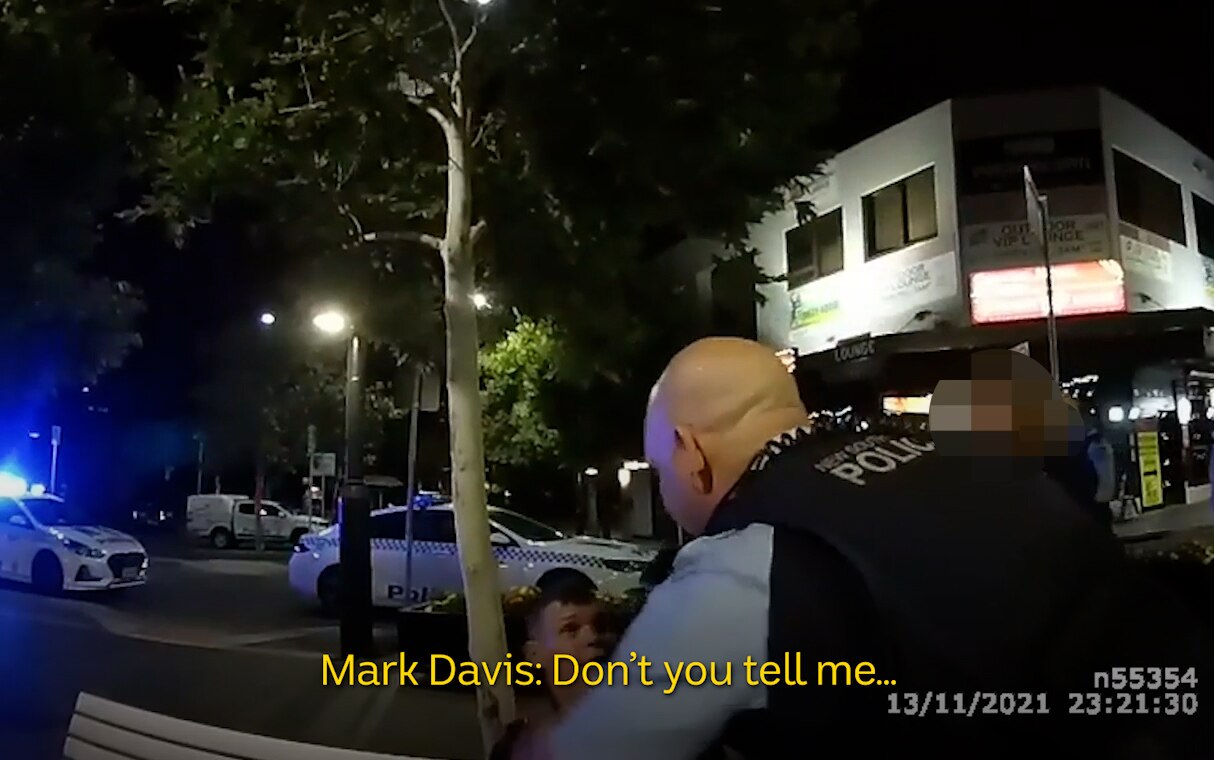 A still from body-worn camera vision of Brad Kellson being handcuffed.