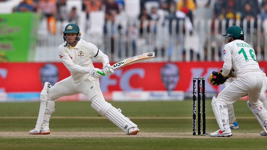 Usman Khawaja plays a shot as the ball pops up with the wicketkeeper looking on