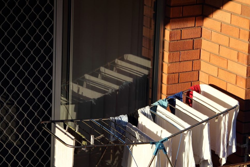 A clothes rack on a small balcony for a story about how often you should change your sheets.