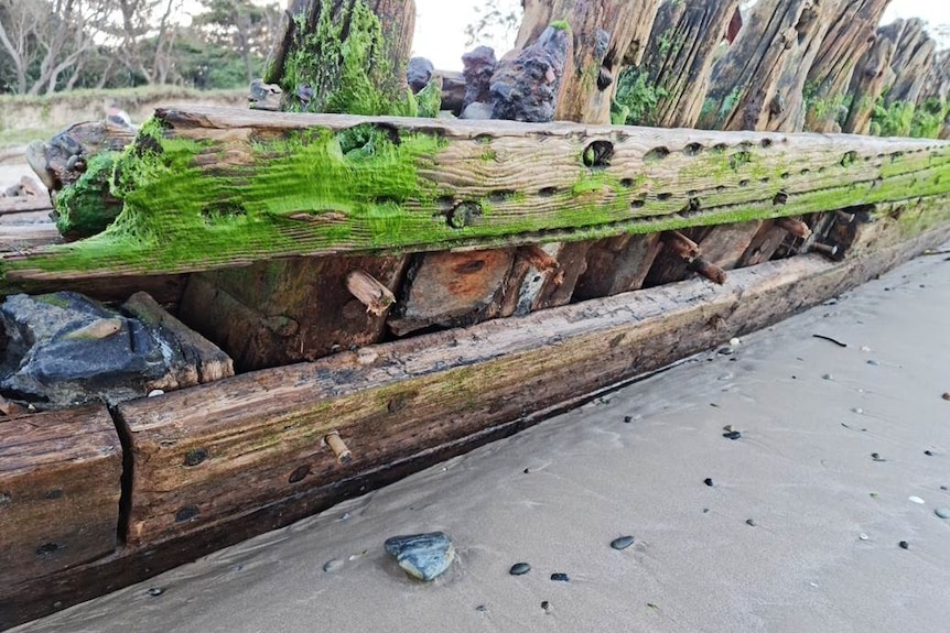 The hull of a shipwreck with a plank missing.