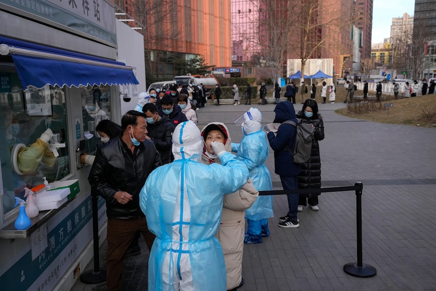 People line up to get a throat swab for the COVID-19 test at a mobile coronavirus testing facility