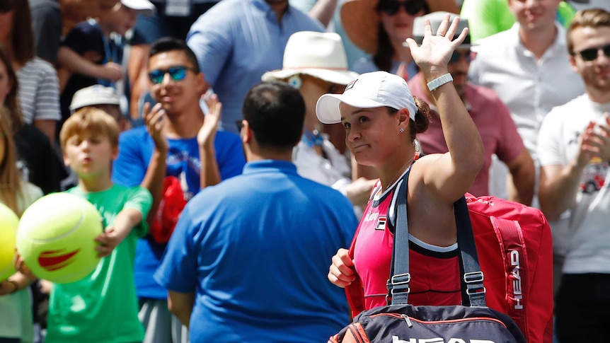 A tennis player ruefully waves goodbye to the crowd after losing at the US Open.