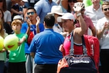 A tennis player ruefully waves goodbye to the crowd after losing at the US Open.