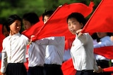 Schoolgirls practice flag-waving ahead of the seventh congress for Korea's ruling party.