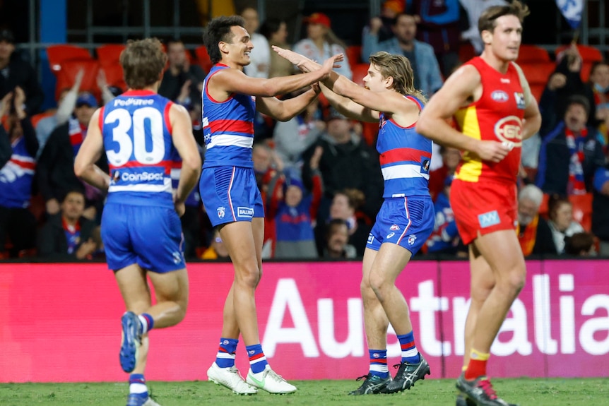 Two Western Bulldogs AFL players congratulate each other after a goal was kicked against Gold Coast.