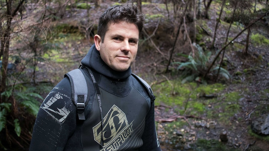 Portrait of Levi Triffitt from Deloraine in wetsuit against wilderness backdrop