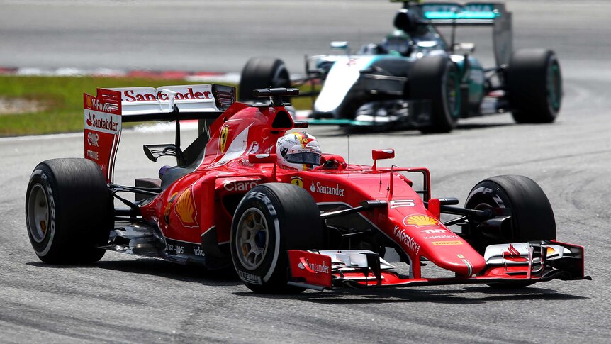 Sebastian Vettel of Germany and Ferrari drives ahead of Nico Rosberg
