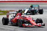 Sebastian Vettel of Germany and Ferrari drives ahead of Nico Rosberg