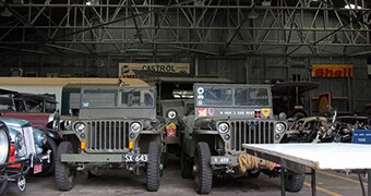Old jeeps inside a hangar.