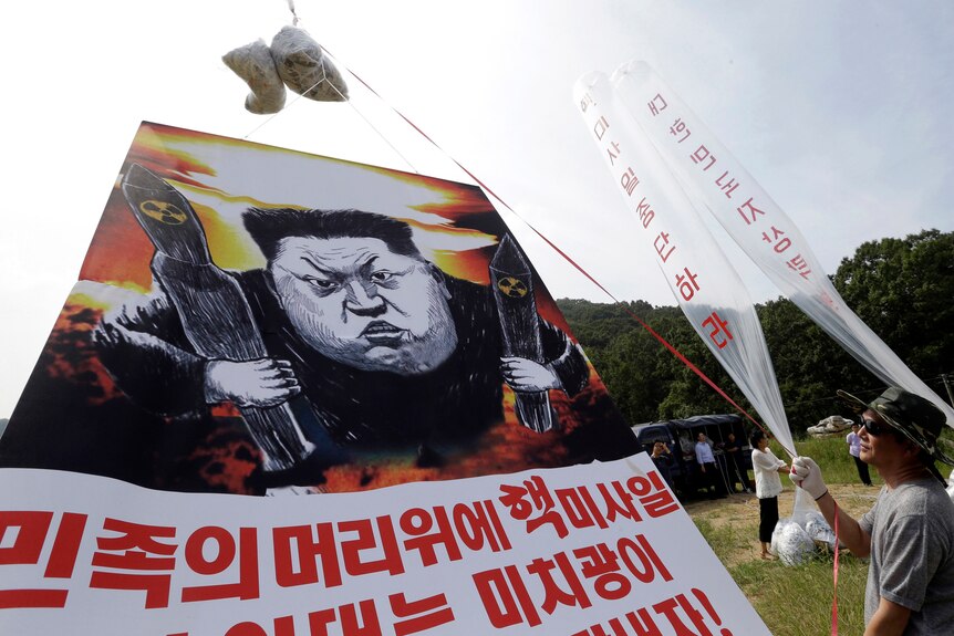  North Korean defectors prepare to release balloons carrying leaflets and a banner denouncing North Korean leader Kim Jong Un