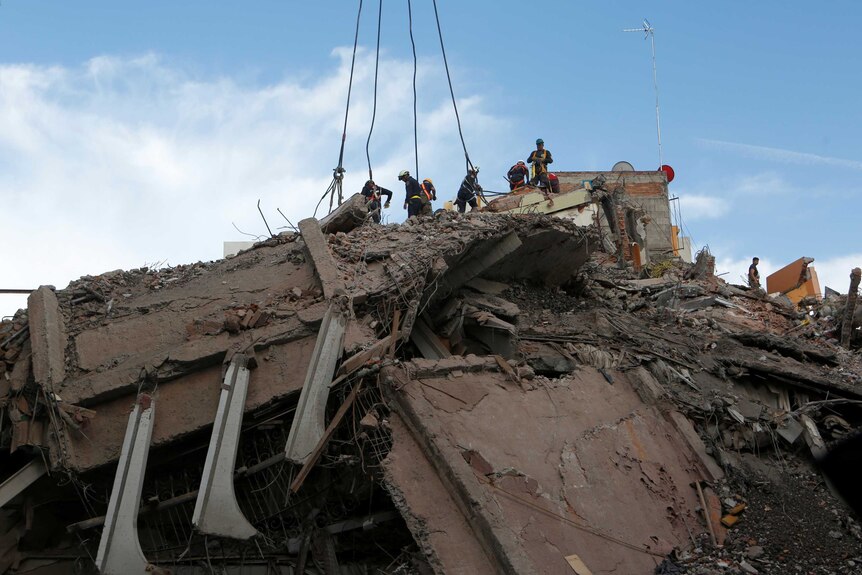 Volunteers work atop a pile of rubble