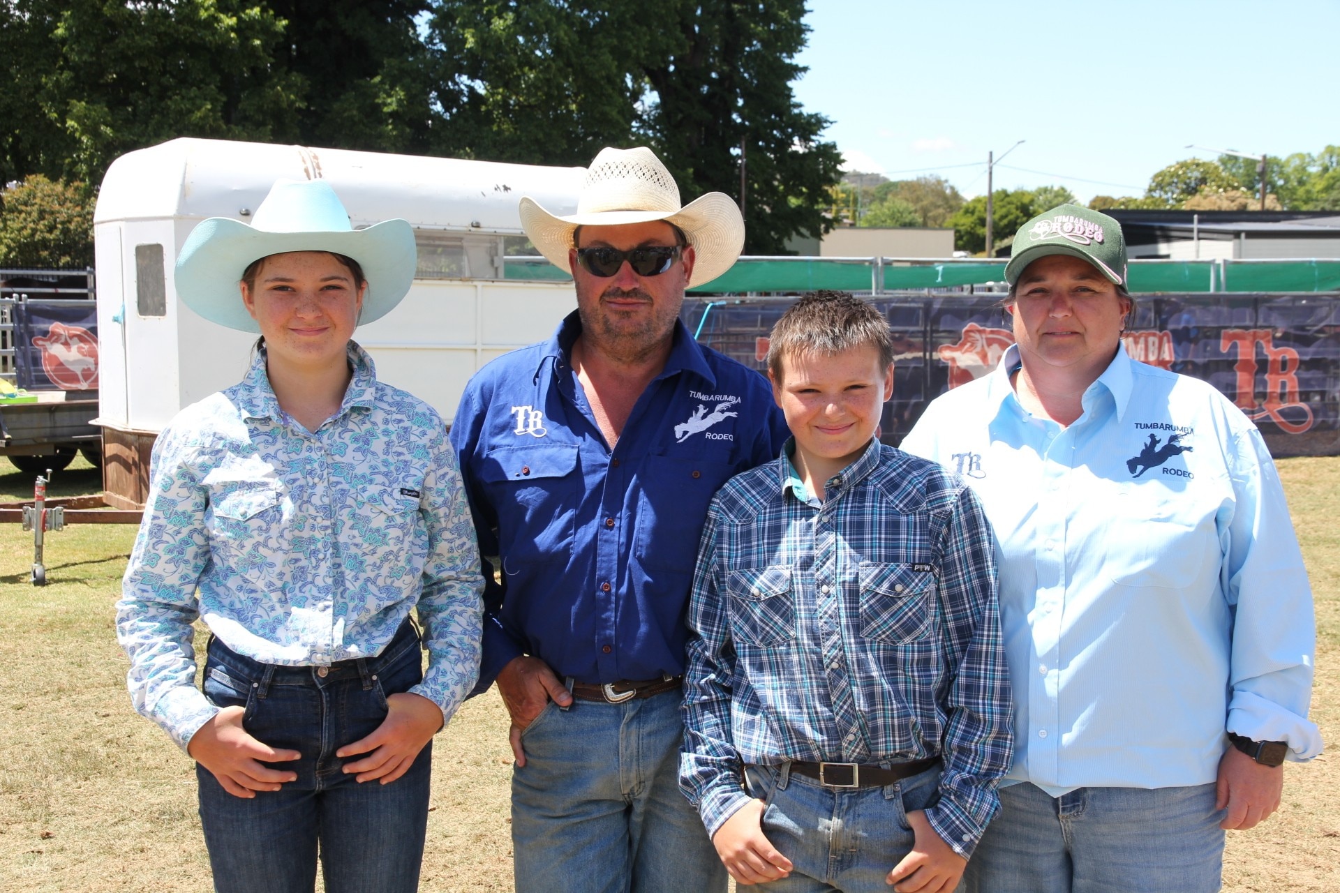 Uma família de quatro pessoas na frente de uma carruagem.