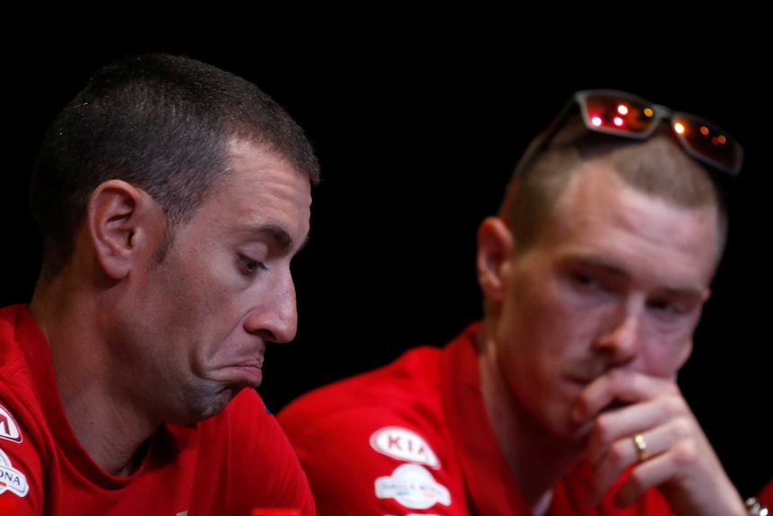 Vincenzo Nibali pulls an indifferent face as teammate Rohan Dennis looks on behind him at a press conference