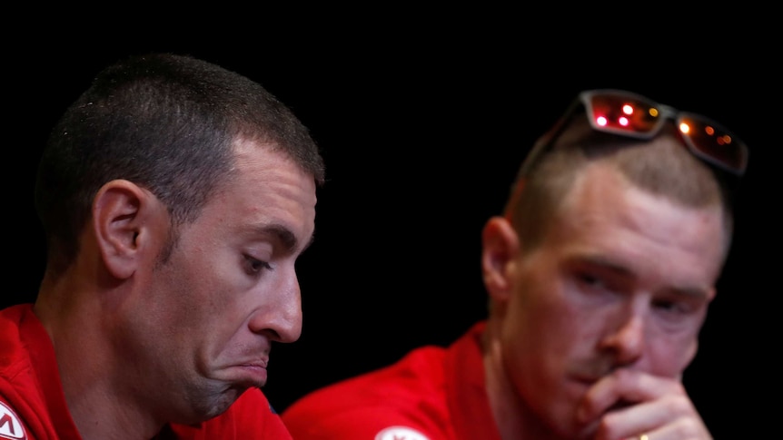 Vincenzo Nibali pulls an indifferent face as teammate Rohan Dennis looks on behind him at a press conference