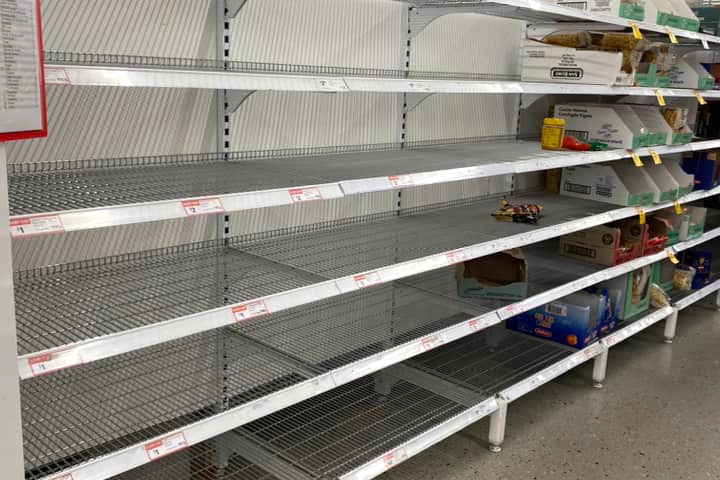 Empty metal shelves at a Coles supermarket.