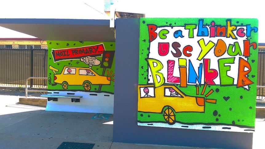 children painting a bus stop with spray paint