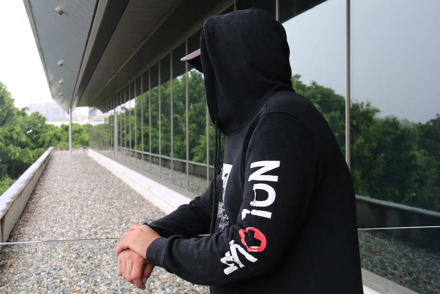 An anonymous former prisoner, wearing a hoodie so you can't see his face