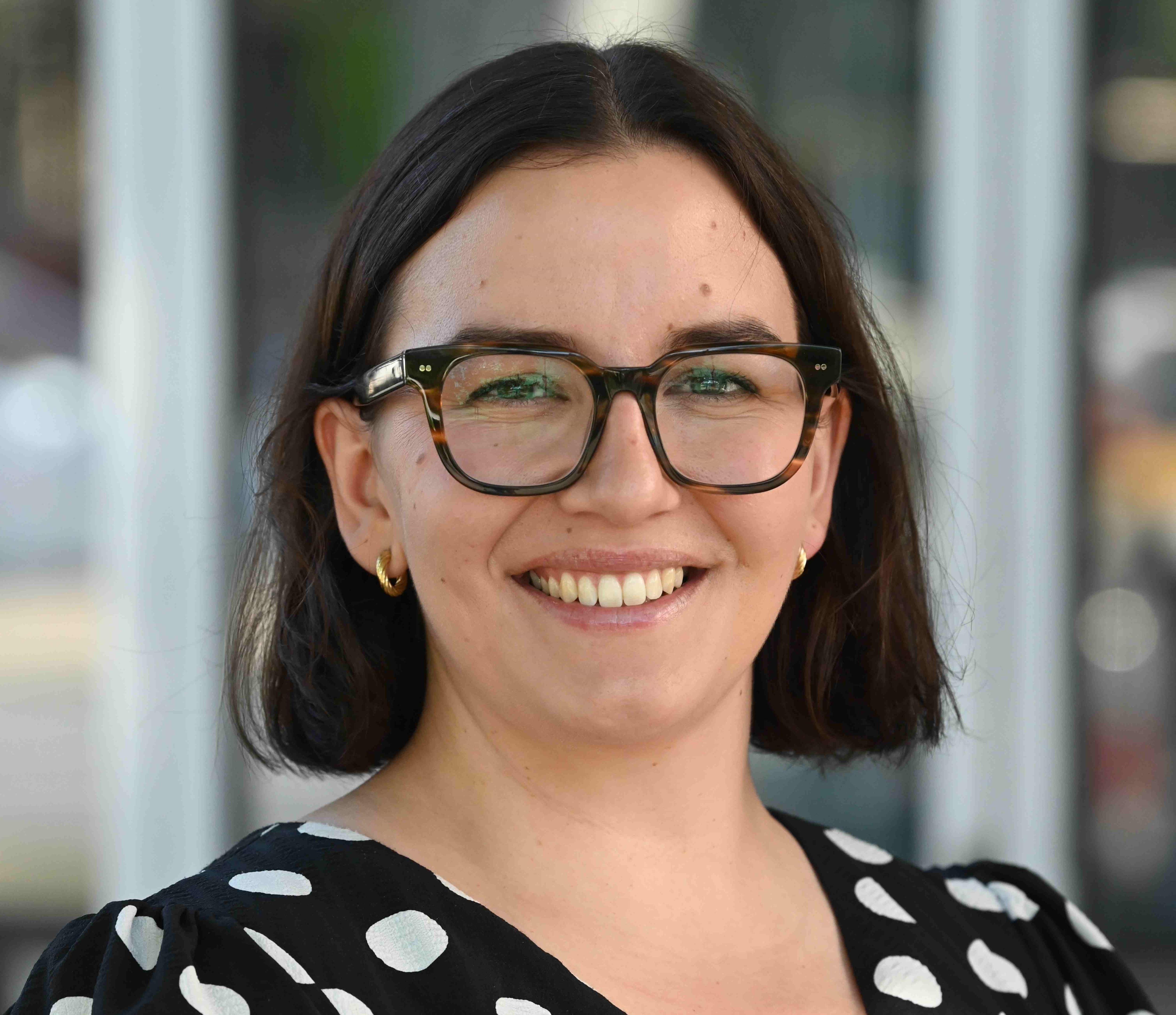 A woman with short black hair and glasses. 