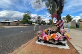 A floral memorial laid by the side of a road.