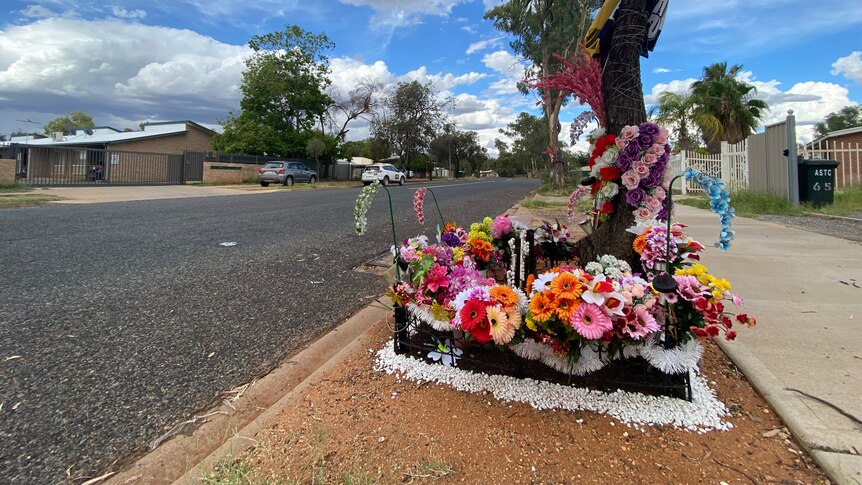 A floral memorial laid by the side of a road.
