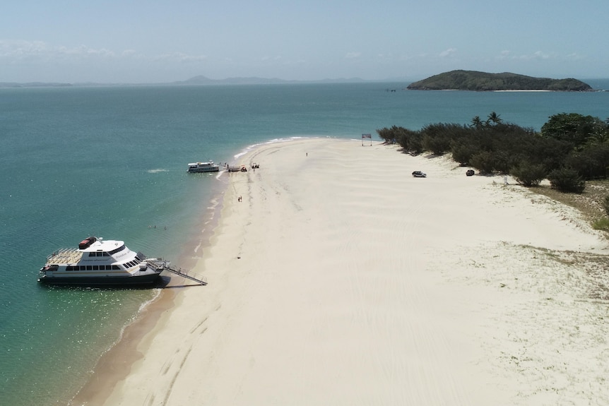 Drone shot of a boat parked up on a tropical island