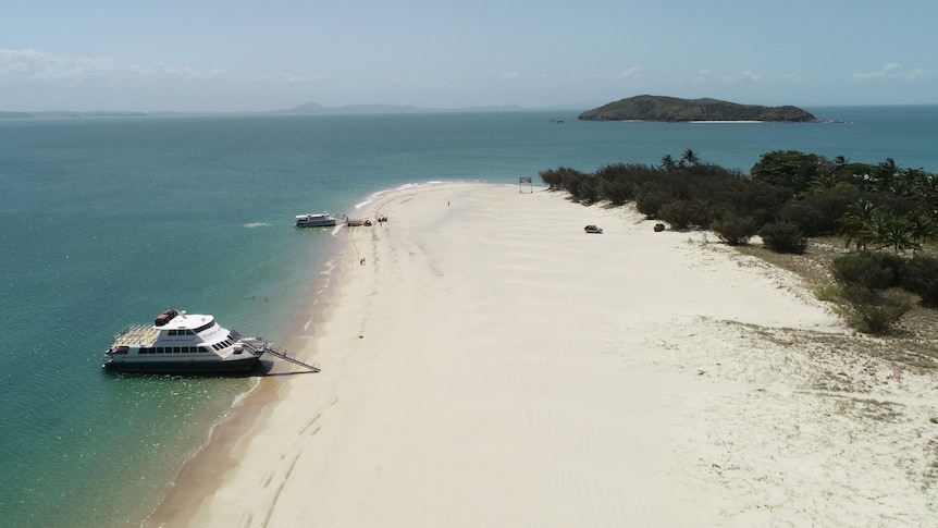 Drone shot of a boat parked up on a tropical island