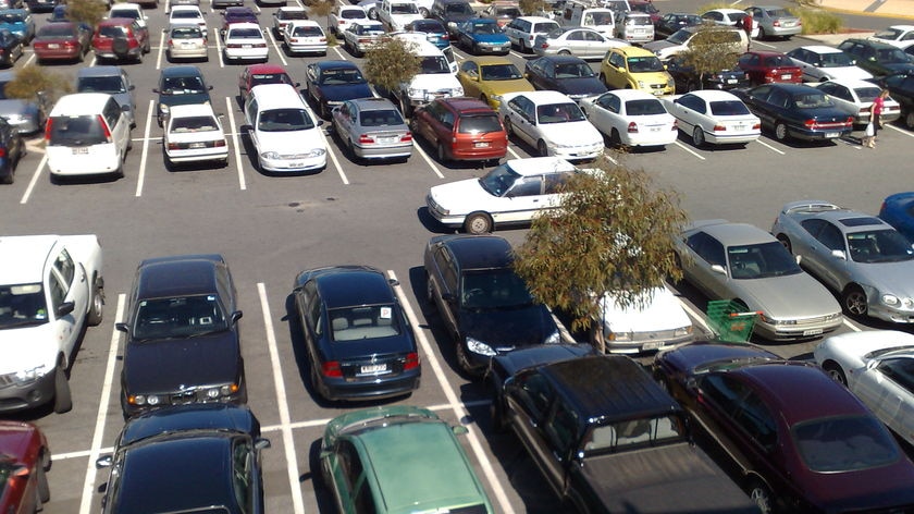 Outside shopping centre car park with vehicles in it.