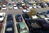 A view from above of a shopping centre at a car park. All the spaces are taken.
