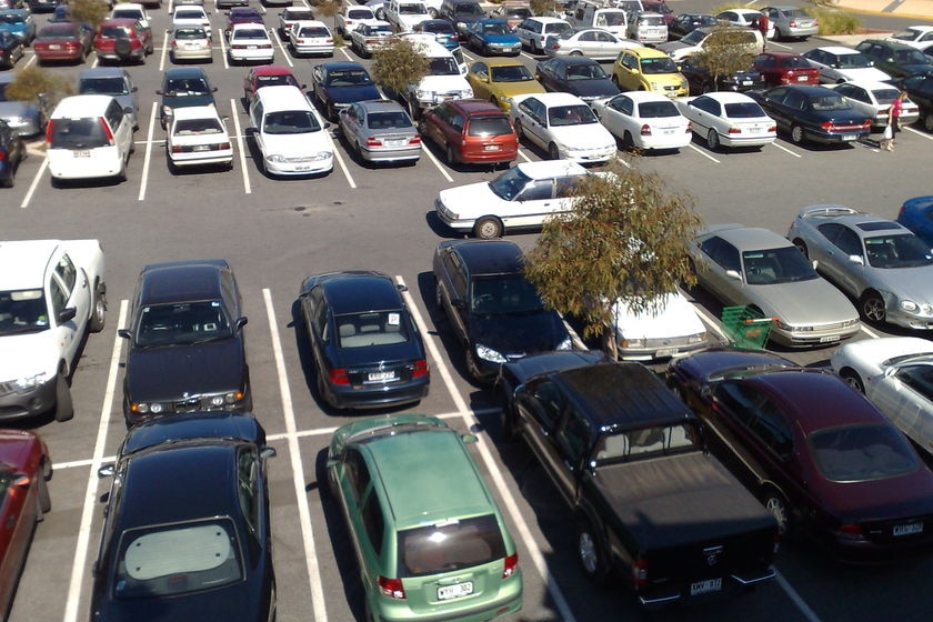 Outside shopping centre car park with vehicles in it.