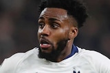 Danny Rose looks at the ball as it bounces at head height with his arms stretched out as Riyad Mahrez runs towards him