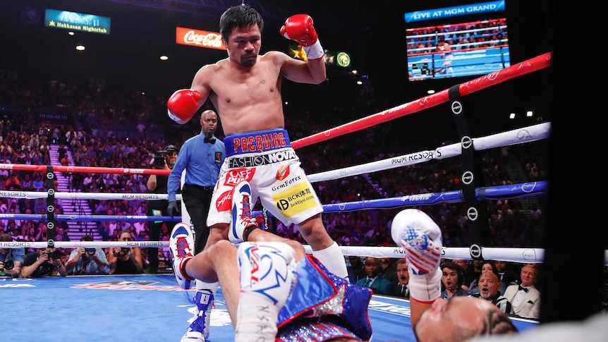 Pacquiao, with gloves raised, stands over Thurman who is lying on the canvas.